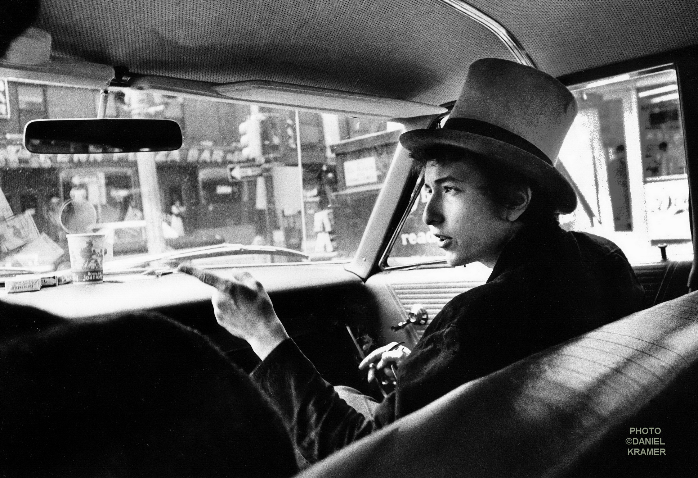Bob-Dylan-WithTop-Hat-Pointing-In-Car-Philadelphia-PA-1964-c-Daniel-Kramer1.jpg